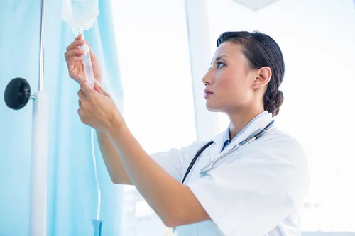 врач устанавливает для пациента общеукрепляющую капельницу